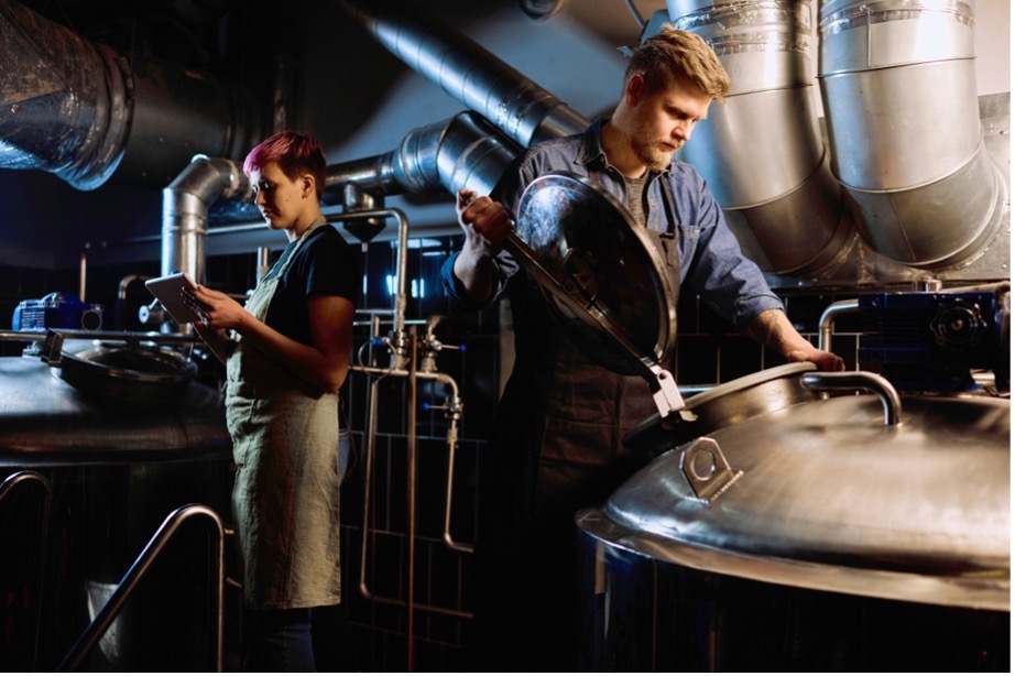 A person and person working at a brewery