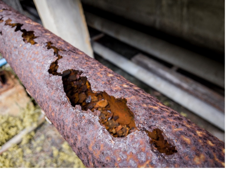 A rusty pipe with holes in it