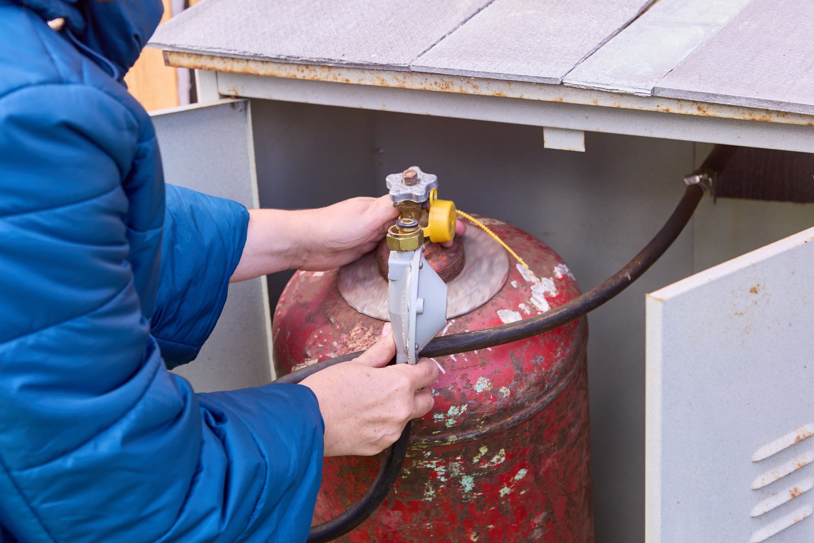 Consumer places filled gas cylinder into cabinet.