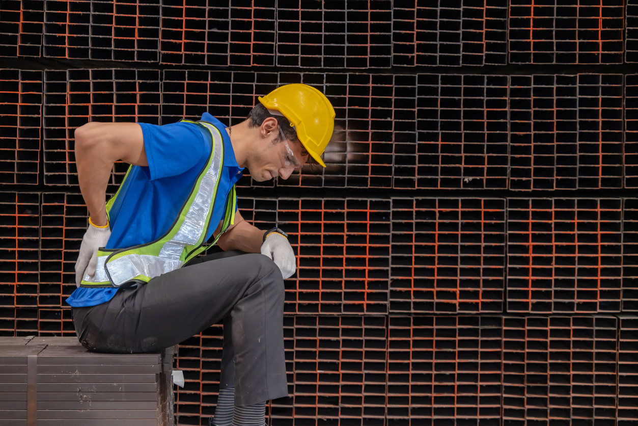 Male worker with back injury suffer from back pain from heavy steel factory work