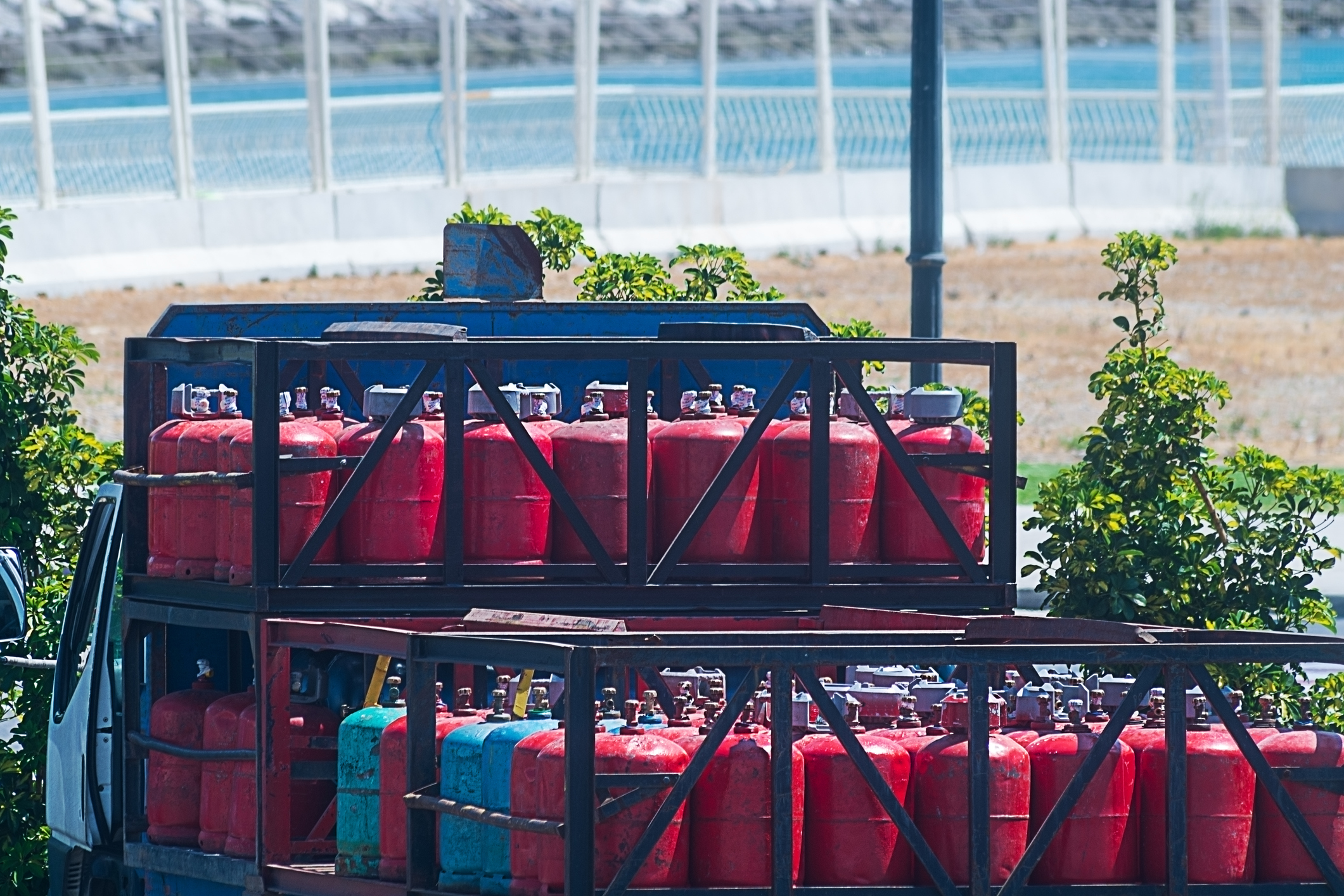 Red small cylinders for gas supply to the population, loaded on the back of a truck for delivery. Cooking and heating equipment.