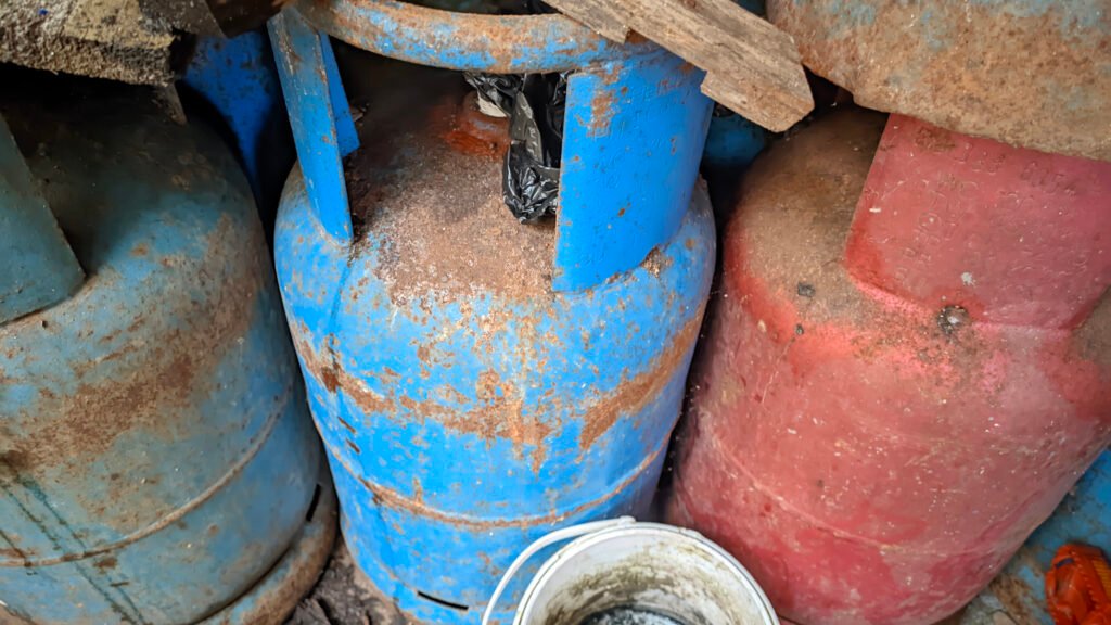 Old rusty blue and red gas cylinders in storage